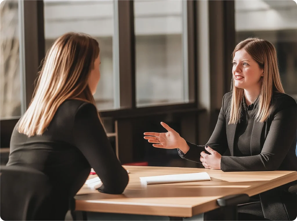gesprek met een vertrouwenspersoon, aan een tafel.